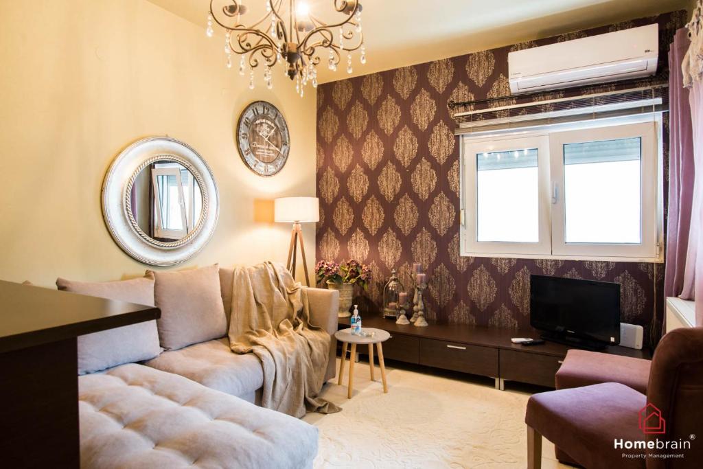 uma sala de estar com um sofá e uma televisão em Deluxe Suite By Homebrain em Alexandroúpolis