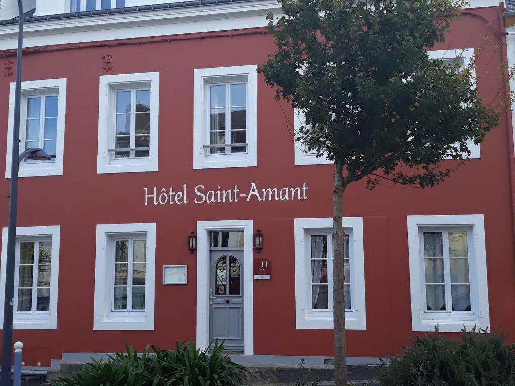 Um edifício vermelho com o homem de Hudson Santant. em Hotel Saint Amant em Le Palais