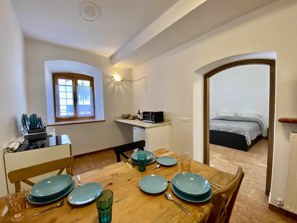 a dining room with a table and a bedroom at Casa Il Geranio Tenna OSPITAR in Tenna 