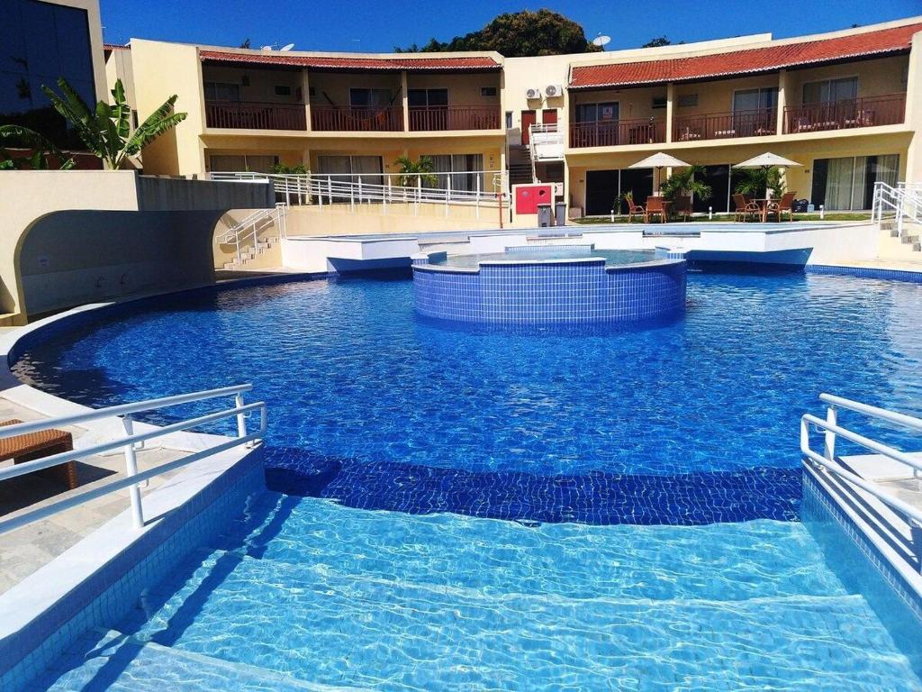 una gran piscina de agua azul frente a un edificio en Solar Agua Flats Elegance Flat, en Pipa