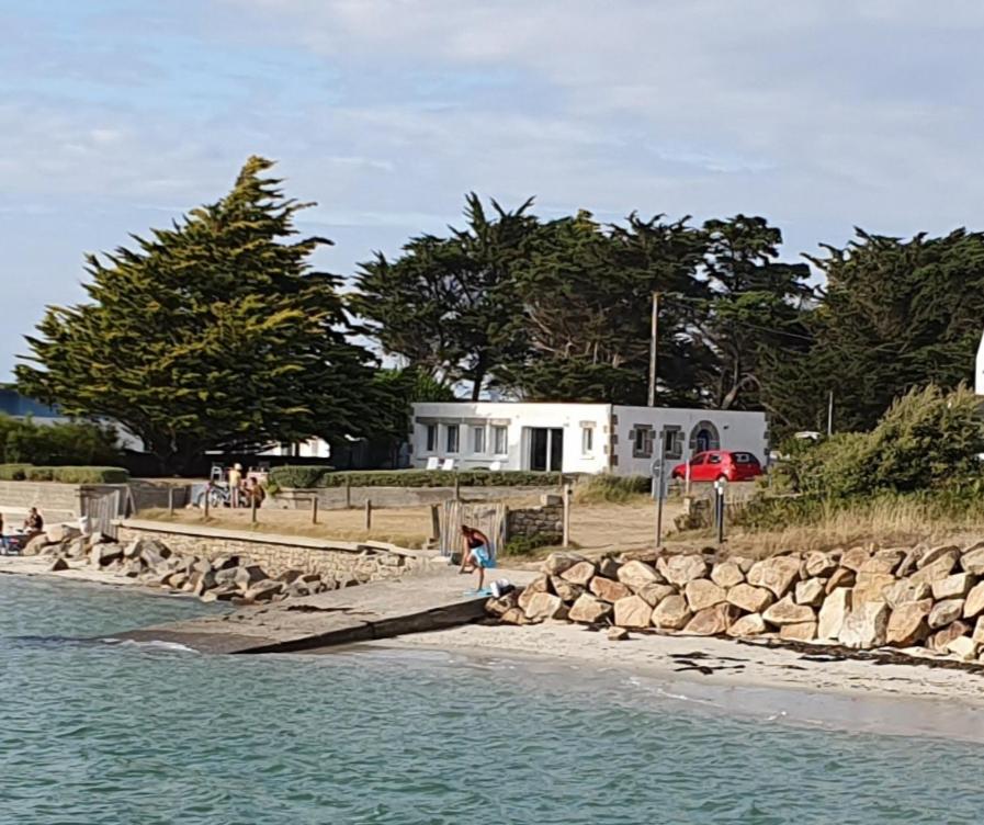 grupa ludzi stojących na plaży blisko wody w obiekcie villa les pieds dans l eau w mieście Carnac