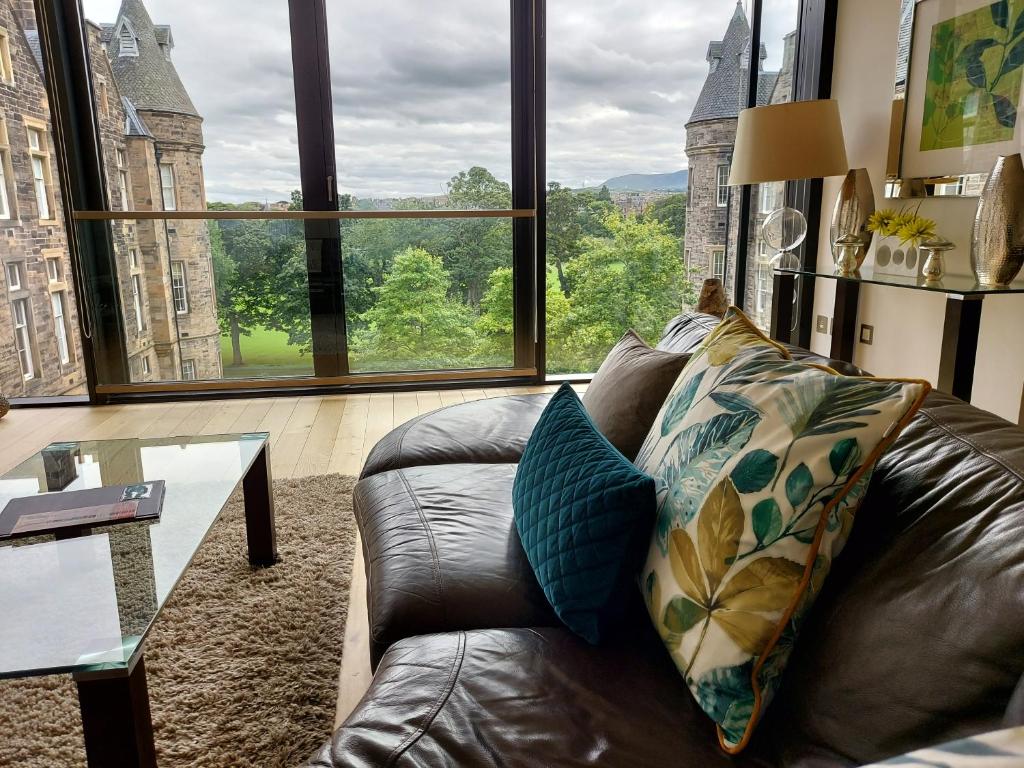 Hotel Quartermile Luxury Landing Apartment, a leather couch in a living room with a large window at Quartermile Luxury Landing Apartment in Edinburgh
