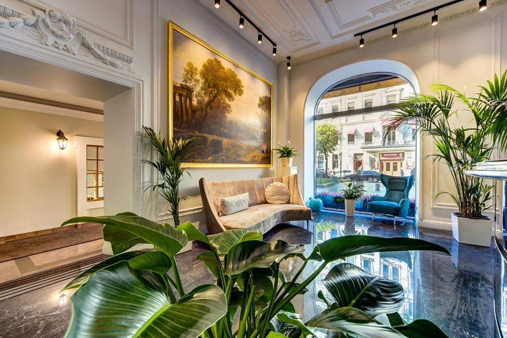 a living room with a couch and some plants at Golden Triangle Boutique Hotel in Saint Petersburg