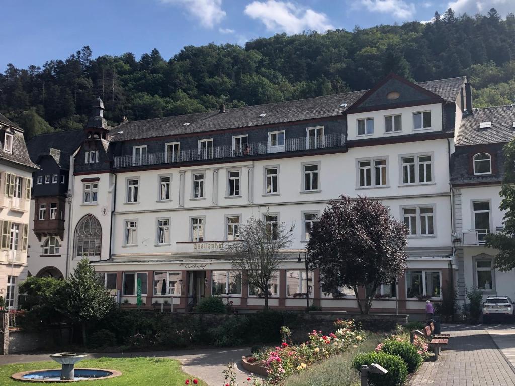 a large white building with a garden in front of it at Kurhotel Quellenhof in Bad Bertrich