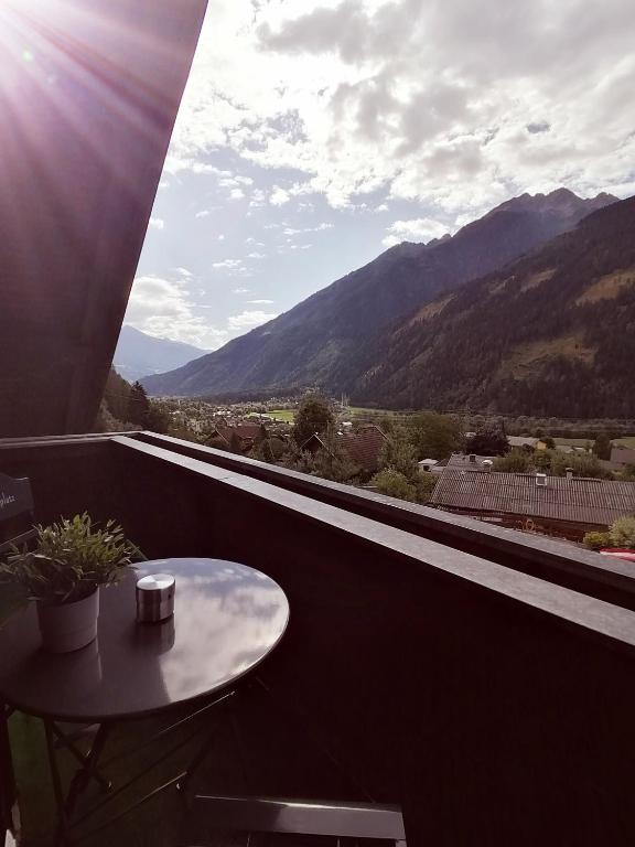 stół na balkonie z widokiem na góry w obiekcie Apartments Zwigl w mieście Flattach
