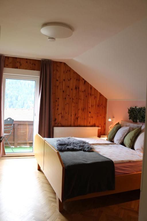 sypialnia z dużym łóżkiem i dużym oknem w obiekcie Apartments Zwigl w mieście Flattach