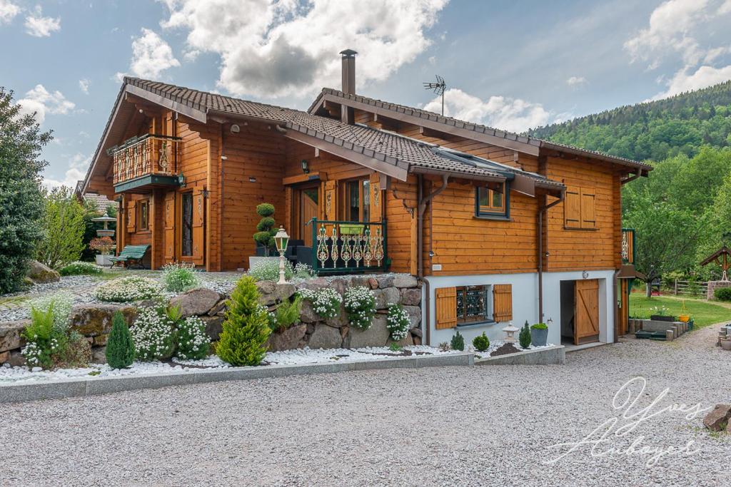 a log house with a porch and a balcony at Chalet La Revoyotte in Le Ménil