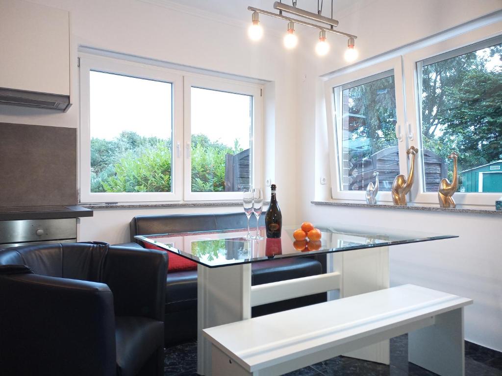 eine Küche mit einem Glastisch und 2 Fenstern in der Unterkunft Gruener Garten in Wilhelmshaven