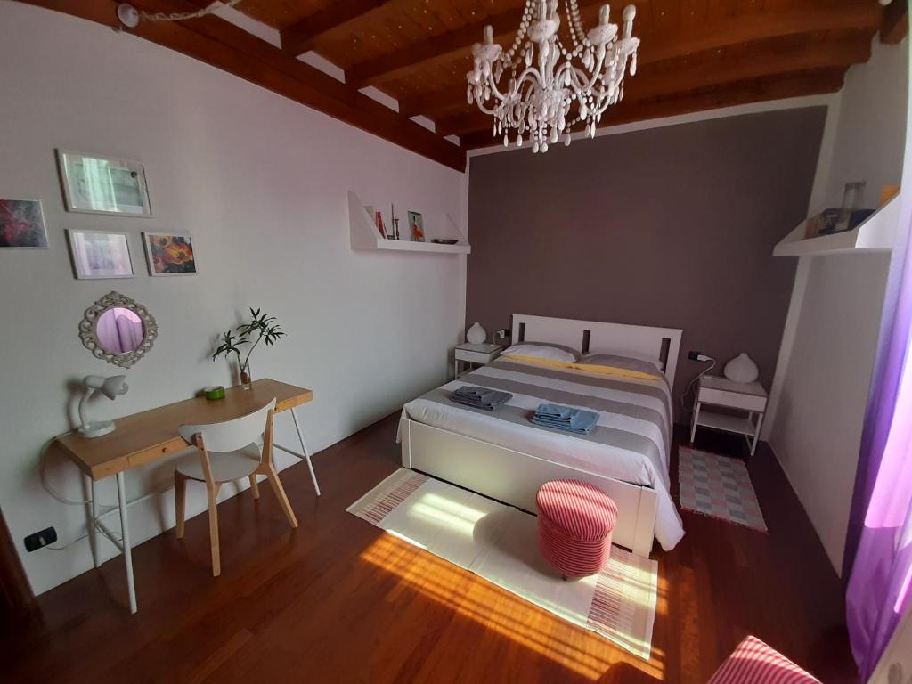 a bedroom with a bed and a table and a chandelier at In Corte al Laghetto in Merate