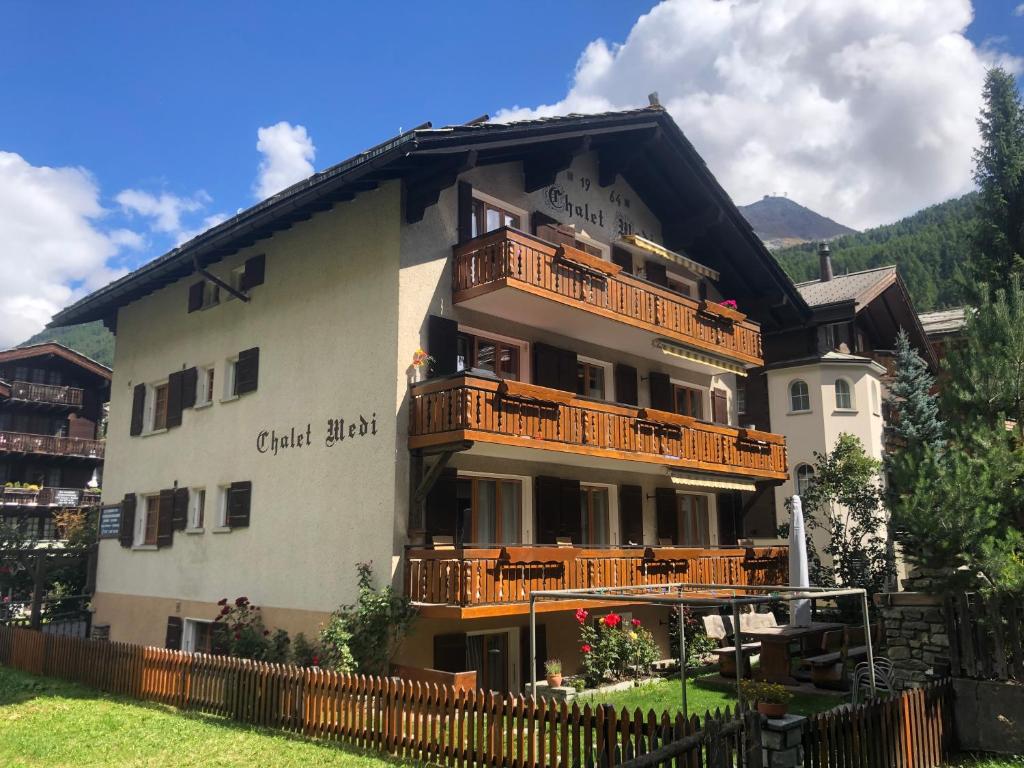 a large building with balconies on the side of it at Chalet Medi in Zermatt