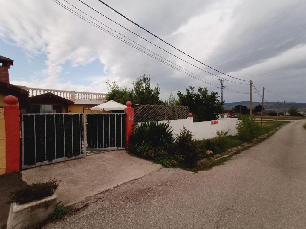 una recinzione sul lato di una strada accanto a una casa di Casa LLANO43 Lago & Montaña a Las Rozas de Valdearroyo
