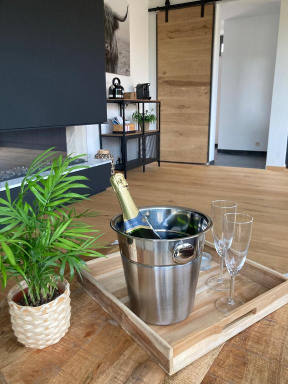 a bottle of wine in a bucket on a tray with glasses at Le 39 Espace Cocoon in Namur