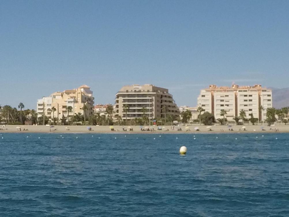 een uitzicht op een strand met gebouwen en een bal in het water bij Sotavento 1ª línea de playa in Roquetas de Mar