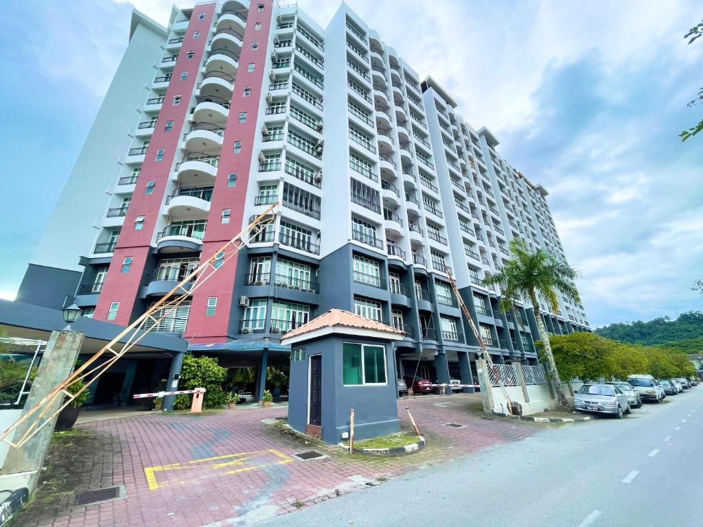 a large apartment building with a palm tree in front of it at Century Suria Aparment Langkawi by Zervin in Kuah