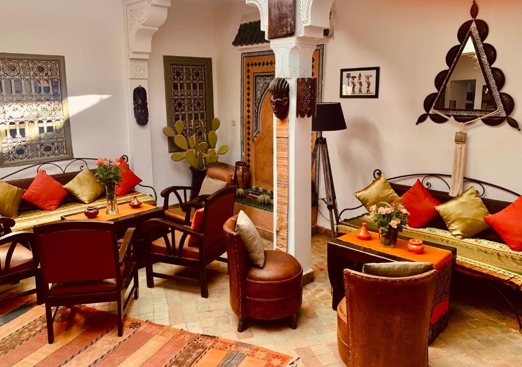 ein Wohnzimmer mit einem Sofa, einem Tisch und Stühlen in der Unterkunft Dar Zemrane in Marrakesch