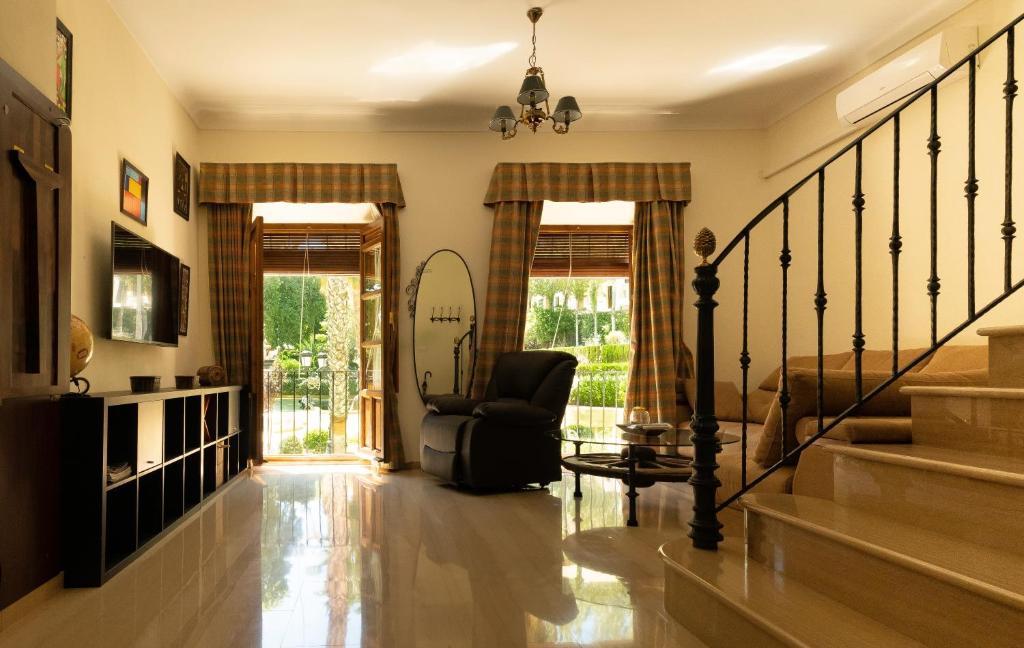 sala de estar con silla y escalera en Alojamiento Turístico Fuente del Rey, en Priego de Córdoba