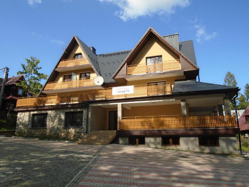 a house with a balcony on the side of it at Willa Halusia in Zakopane