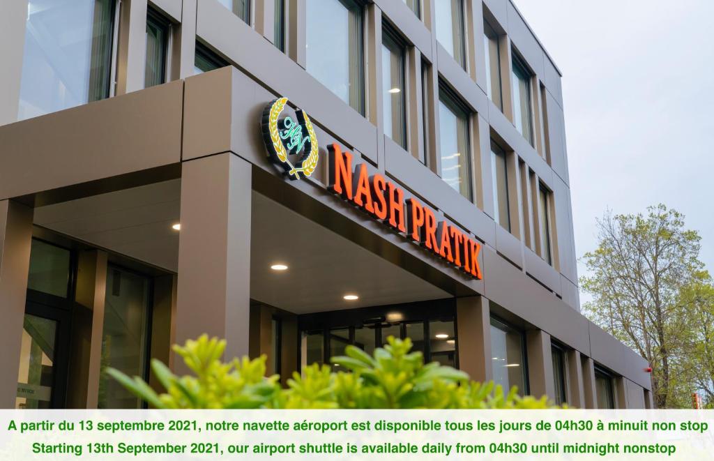 un bâtiment avec un panneau sur son côté dans l'établissement Nash Pratik Hotel, à Genève