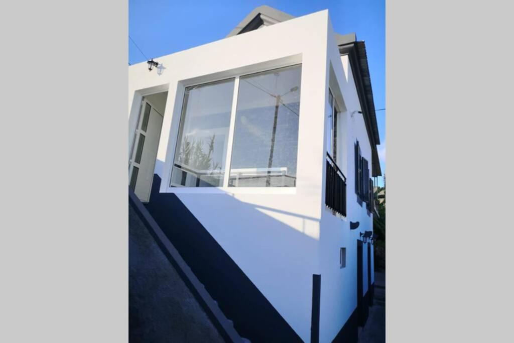 a white house with a staircase leading up to the door at Isabela House in Ponta do Sol