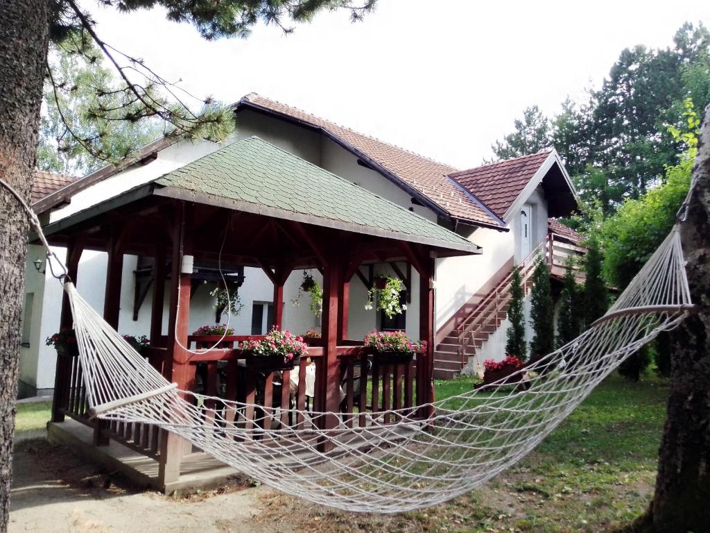 a hammock in front of a house at Apartmani Eho Zlatibor in Zlatibor