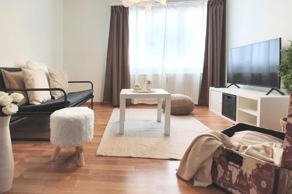 a living room with a white table and a tv at Bright and modern apartment in the heart of Altstätten in Altstätten