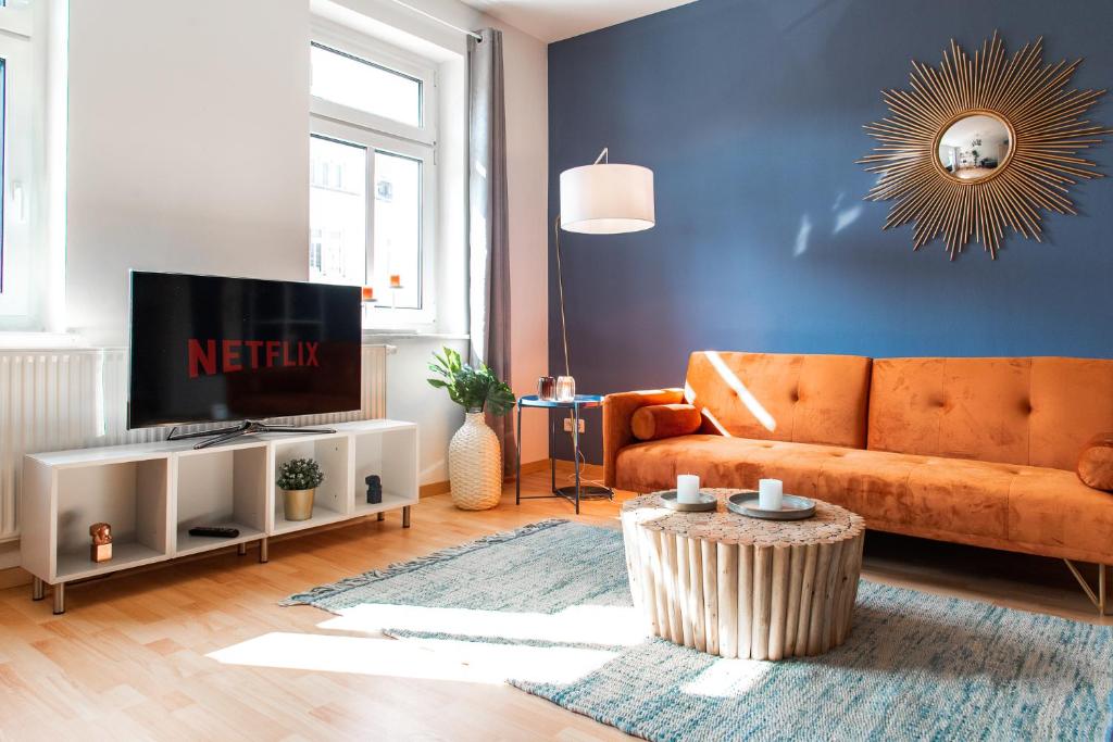 - un salon avec un canapé et une télévision dans l'établissement Stilvolles Apartment mit Balkon / Netflix + WIFI & zentrumsnah, à Chemnitz