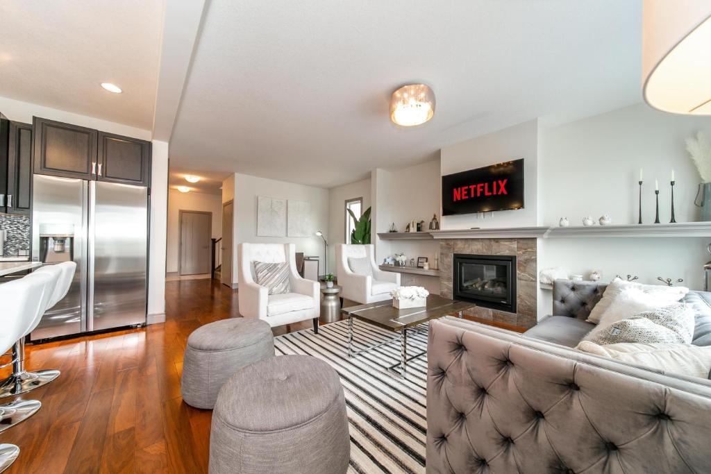 a living room with a couch and a fireplace at Lakeview Luxury Home - Double Garage Parking - Foosball Table - King Beds - Fast Wi-Fi -Free Netflix in Edmonton