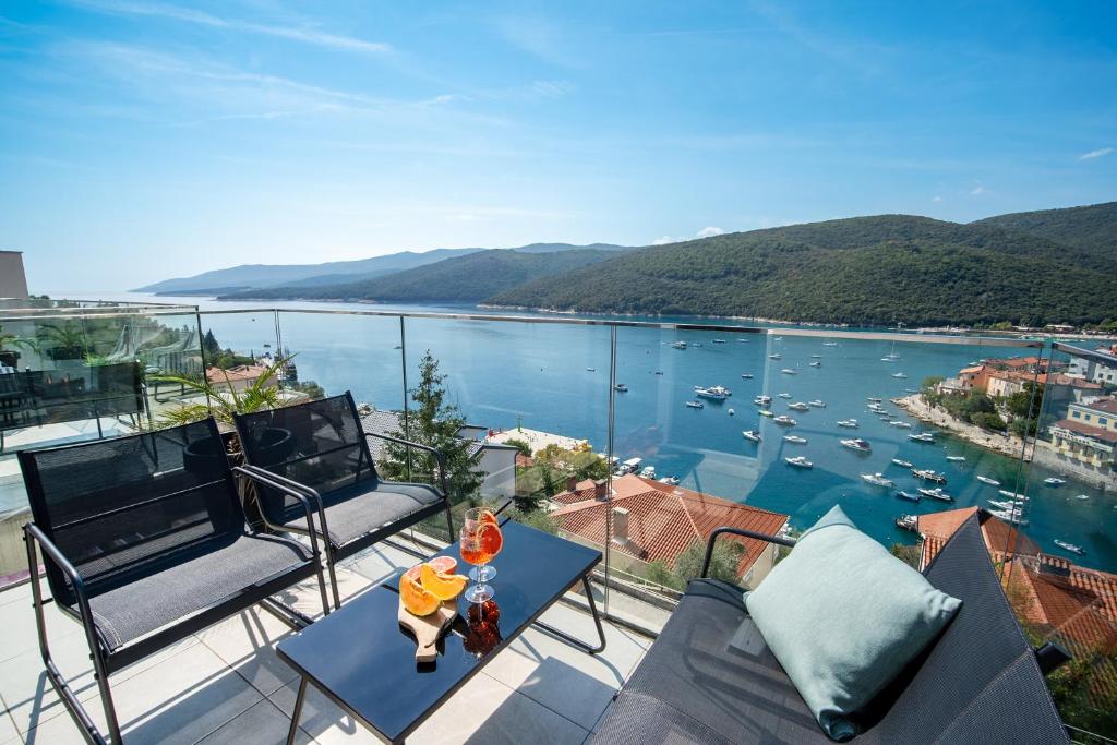 uma varanda com vista para um corpo de água em Apartments Palma Rabac em Rabac