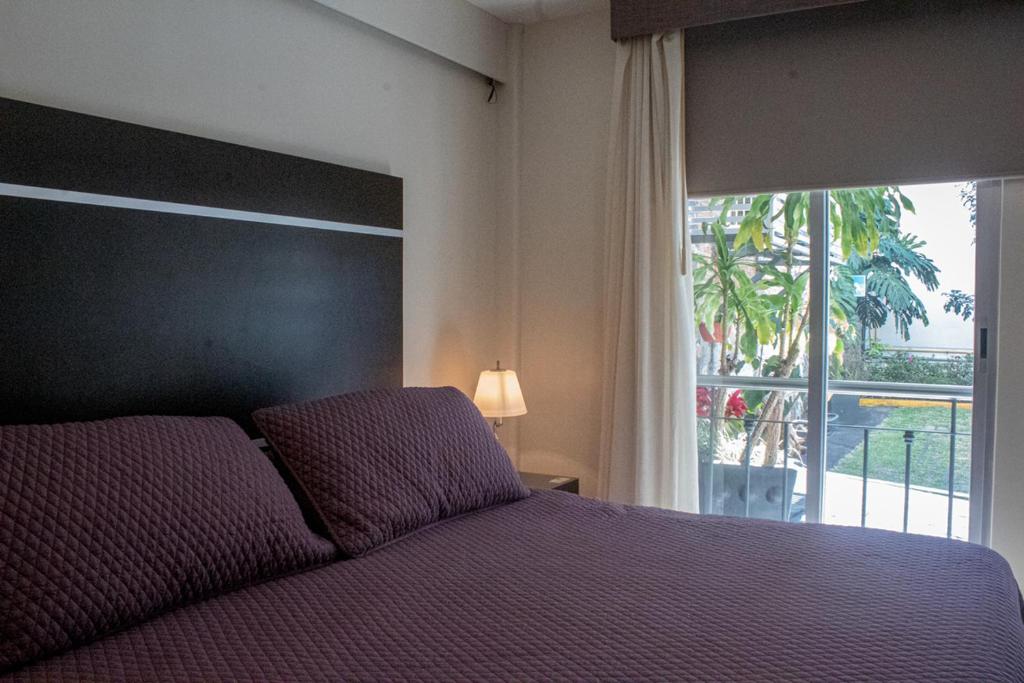 a bedroom with a bed and a large window at Hotel San José Plaza Coatepec in Coatepec