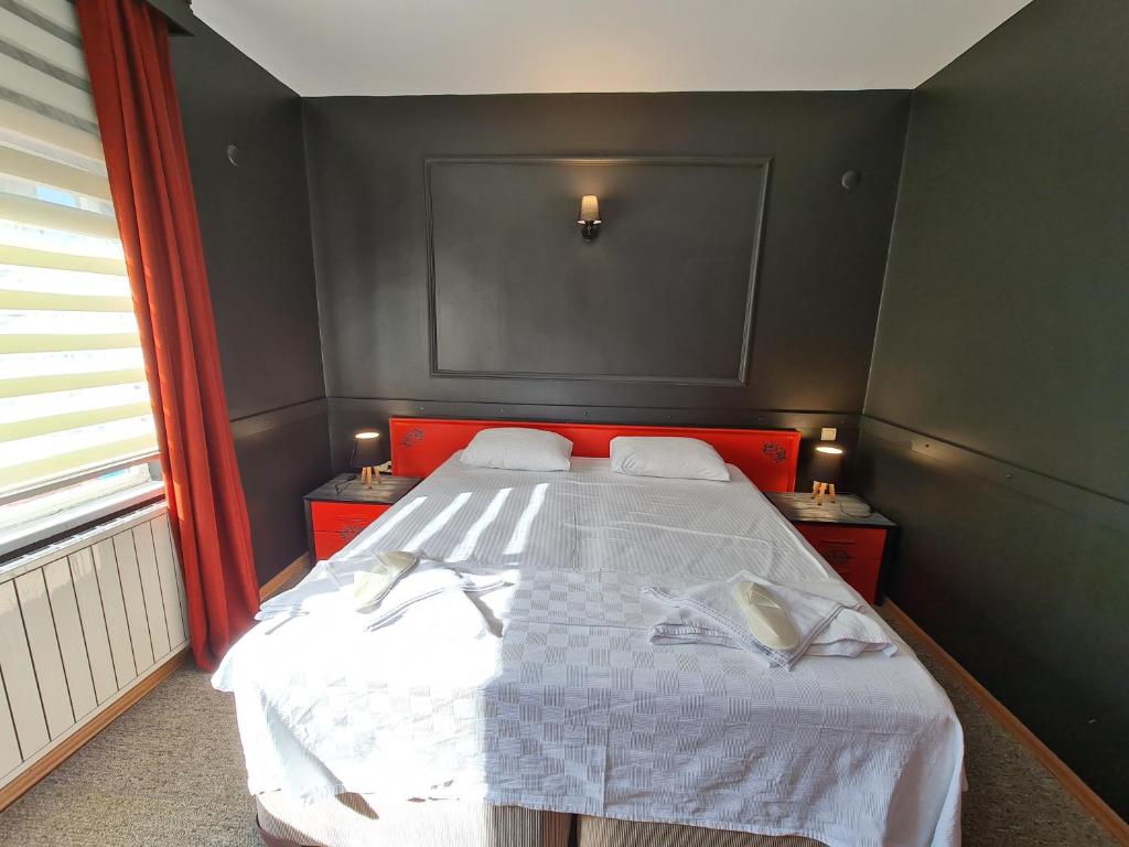 1 dormitorio con 1 cama grande y cabecero rojo en SPORKÖY HOTEL & BEACH CLUB en Kocaeli