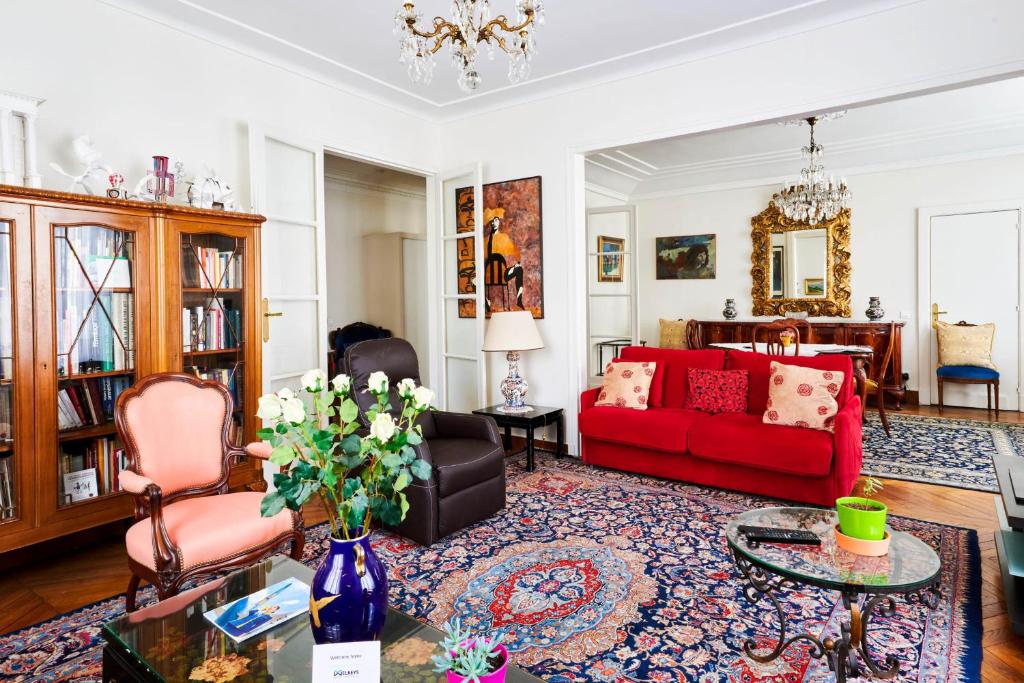 a living room with a red couch and chairs at Superb flat two steps away from Porte Maillot in Paris - Welkeys in Paris