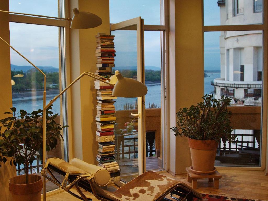 un soggiorno con lampada e una pila di libri di High End Budapest in the city center a Budapest