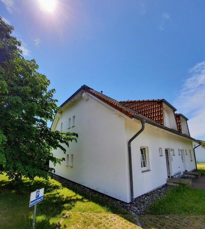 a white house with a tree next to it at Sonne in Neddesitz