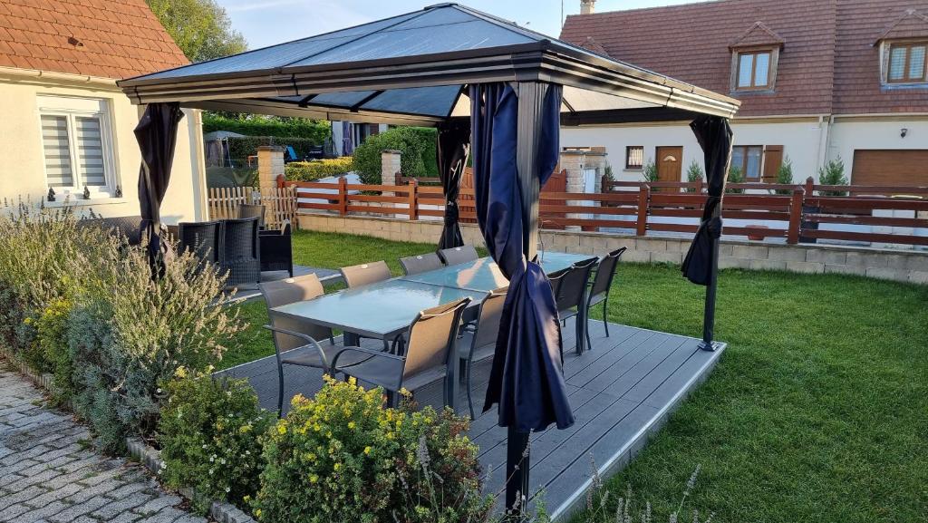 a patio with a table and chairs under a canopy at chez christian&astrid Next to Disneyland Paris in Penchard