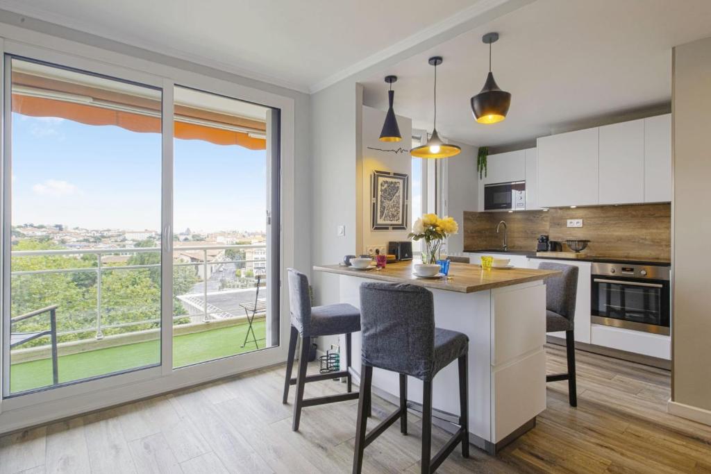 uma cozinha com mesa e cadeiras e uma grande janela em Flat with terrace and incredible view in Biarritz - Welkeys em Biarritz