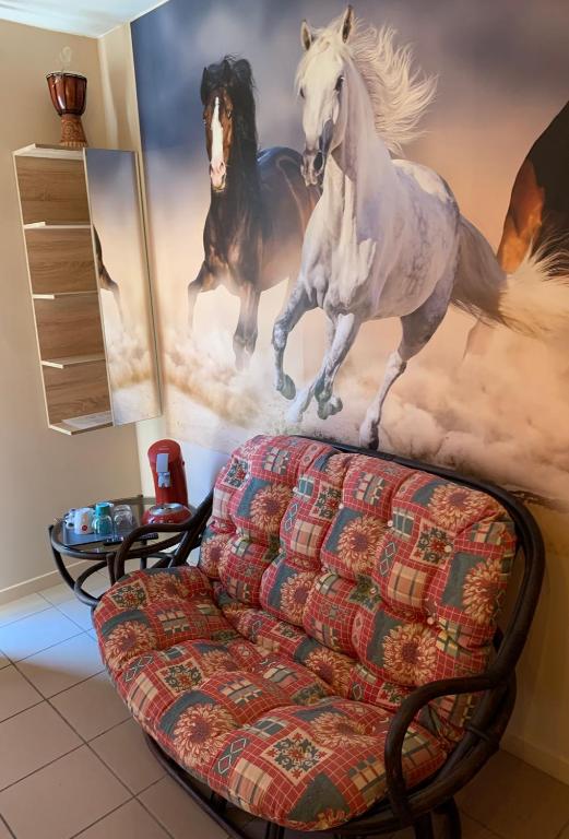 a living room with a painting of horses on the wall at Carpe Diem in Jumet