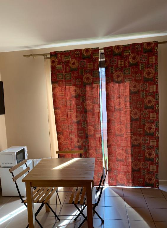 a table and chairs in a room with red curtains at Carpe Diem in Jumet