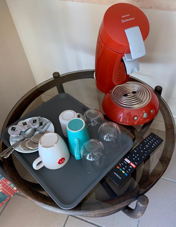 a table with a coffee maker and cups on it at Carpe Diem in Jumet