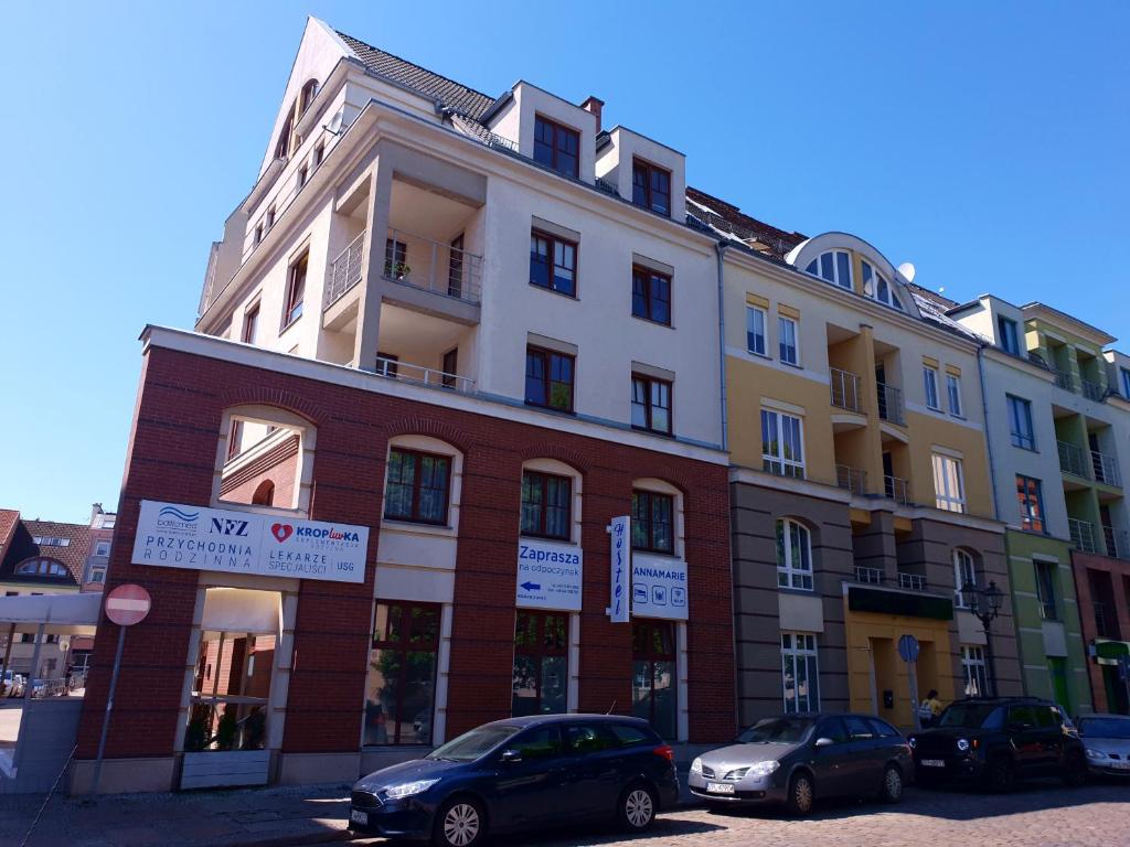 a building with cars parked in front of it at Hostel Annamarie in Szczecin