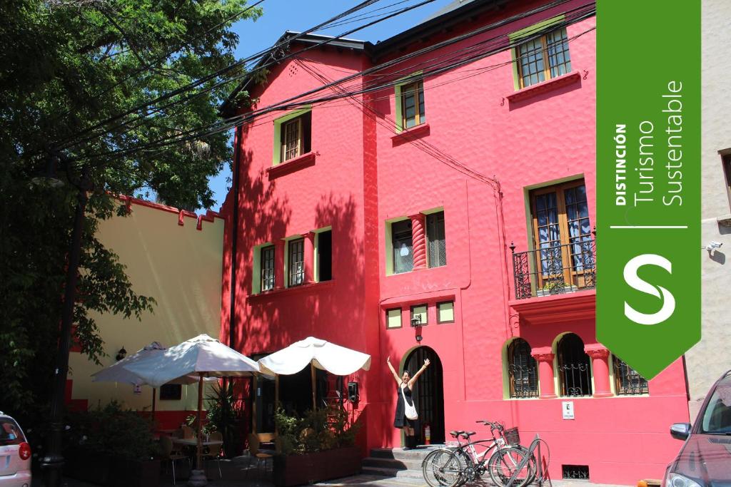 a pink building next to a red building at Aji Hostel in Santiago