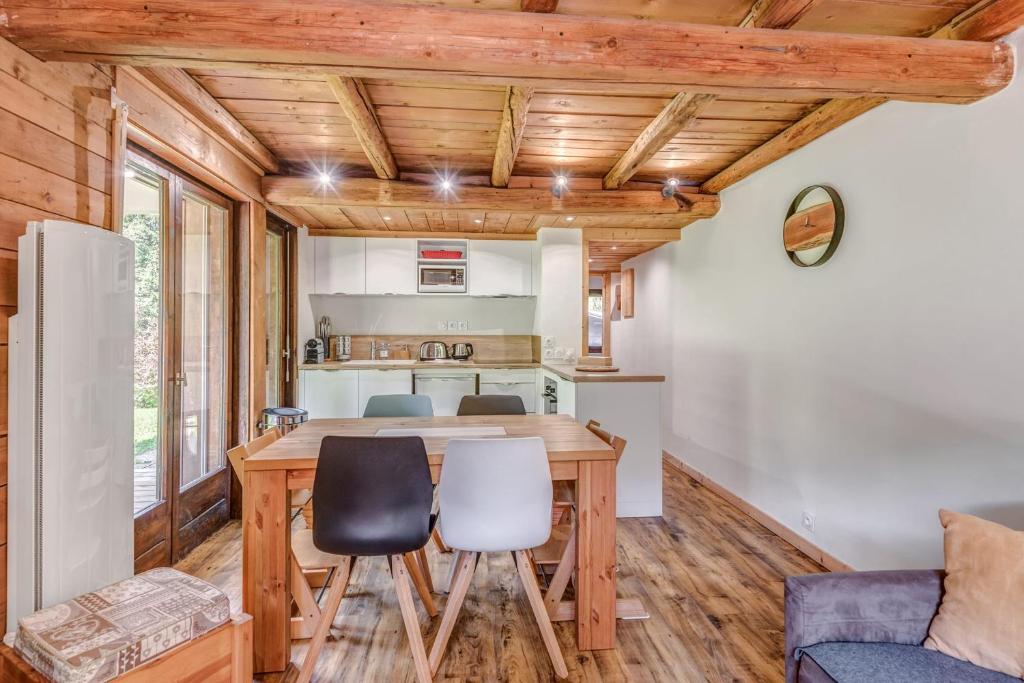 une cuisine et une salle à manger avec une table et des chaises dans l'établissement Appartement des Cerisiers - Welkeys, à Megève