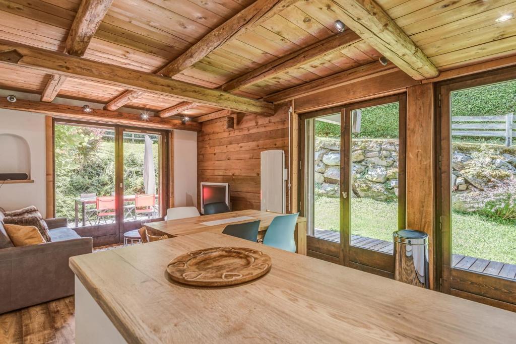 a living room with a table and chairs and windows at Cosy flat with terrace and parking nearby the ski runs in Megève - Welkeys in Megève