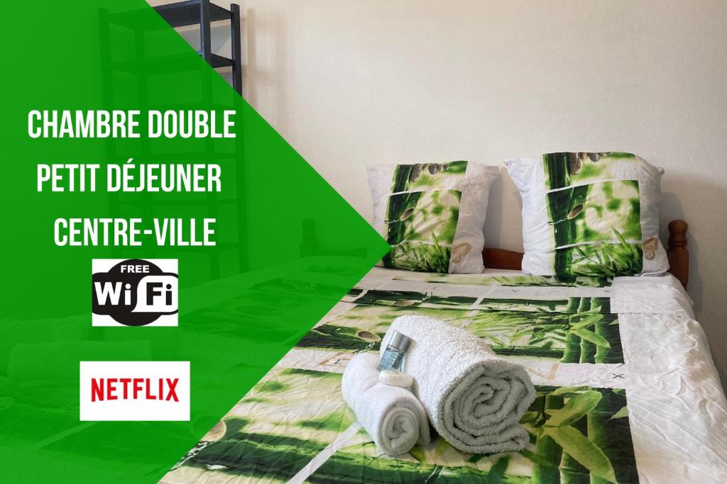 Una cama verde y blanca con toallas. en Le Carbet du Centre-Ville - CLIM-CENTRE-VILLE-WIFI-PARKING-NETFLIX, en Saint-Laurent-du-Maroni