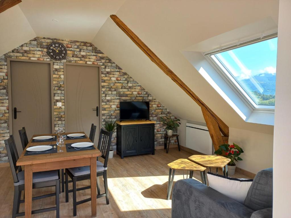 a living room with a table and a window at Logement entièrement rénové au cœur du Val d'Azun in Arras-en-Lavedan