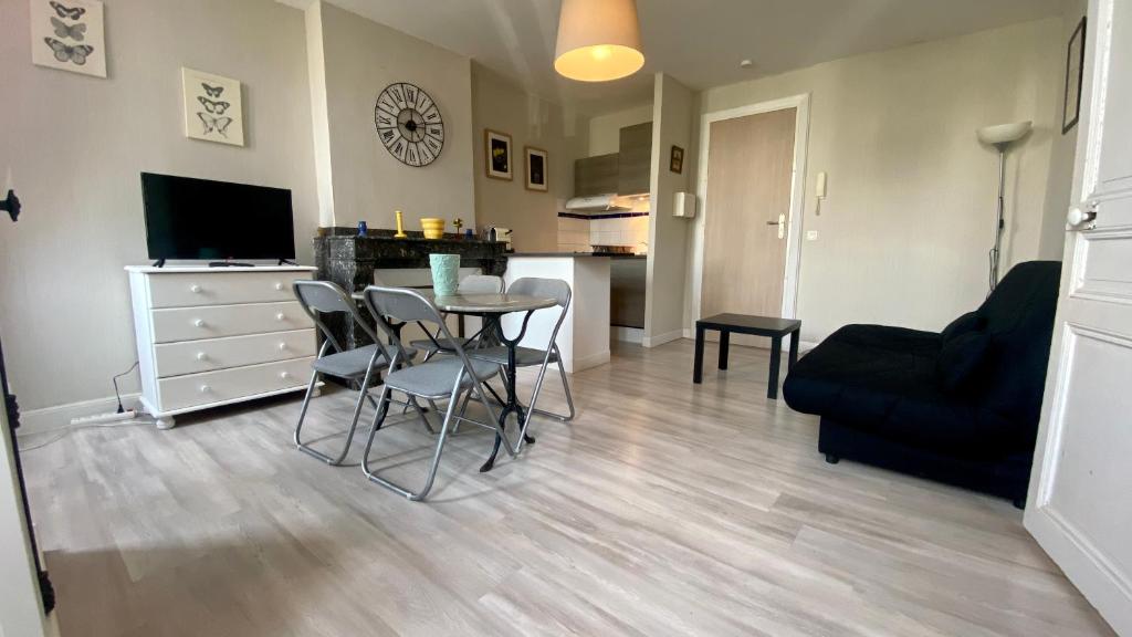 ein Wohnzimmer mit einem Tisch, Stühlen und einem Sofa in der Unterkunft Aurore Appartements Carcassonne in Carcassonne