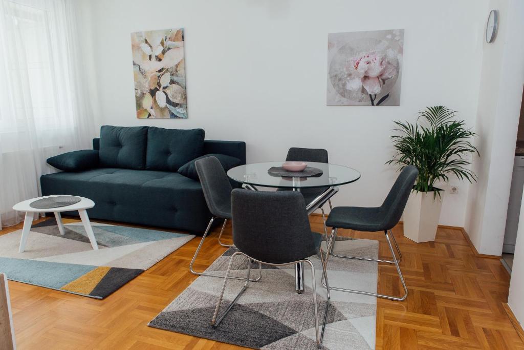 salon z kanapą, stołem i krzesłami w obiekcie Suite Dreams w mieście Valjevo