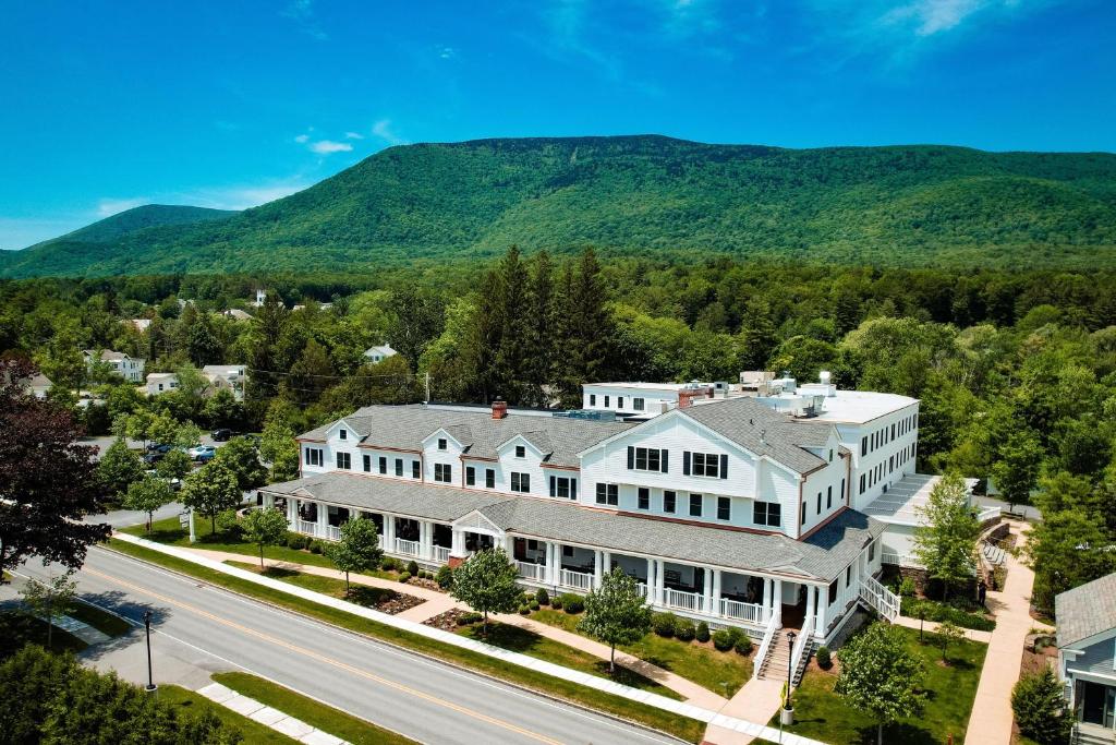 an aerial view of a large white house with mountains in the background at Kimpton Taconic Hotel by IHG in Manchester