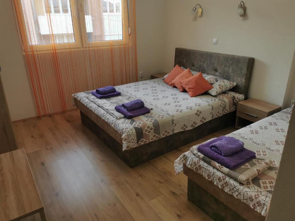 1 dormitorio con 2 camas y toallas moradas. en Studio apartmani Manila -bazeni, popust, Terme -VAUČERI, en Vrnjačka Banja