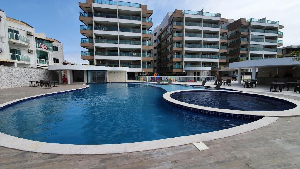 a large swimming pool in front of a building at Apartamento Ninho das Gaivotas - Praia dos Anjos Residence - 2 Vagas in Arraial do Cabo