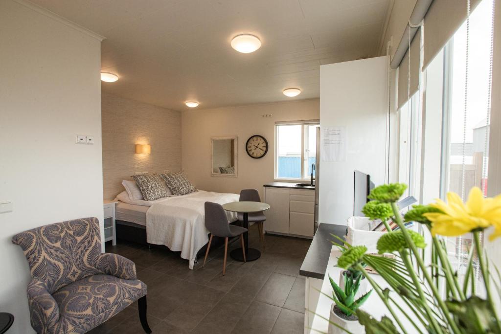 ÞórshöfnにあるCave apartmentのベッドルーム1室(ベッド1台、テーブル、椅子付)